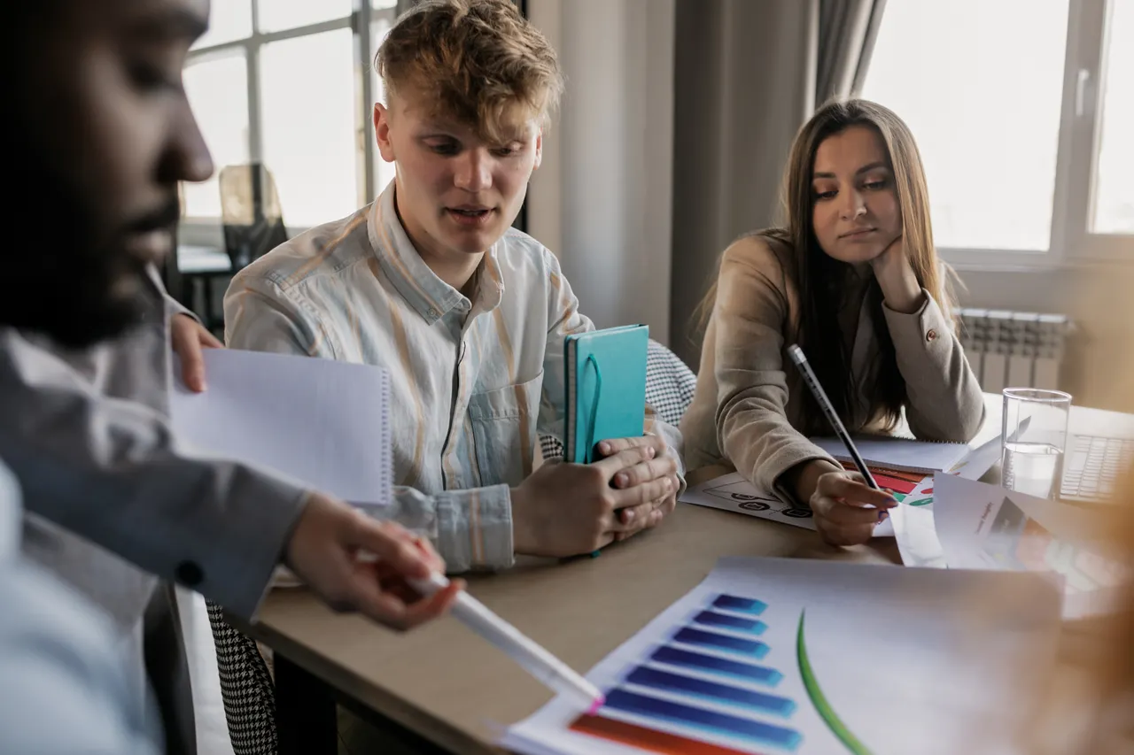 Team coordination — colleagues reviewing information together during a meeting
